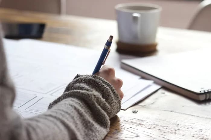 A candidate taking notes while preparing an application